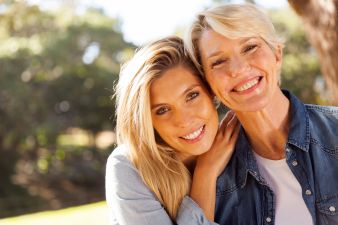 happy middle aged blond mother and adult daughter