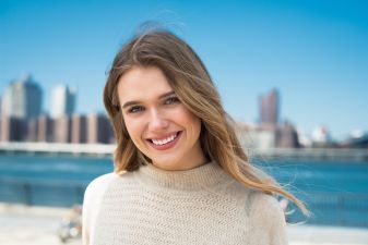 smiling young woman against the city