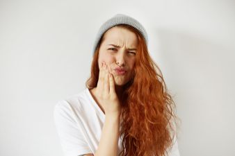 red haired woman with a sore tooth