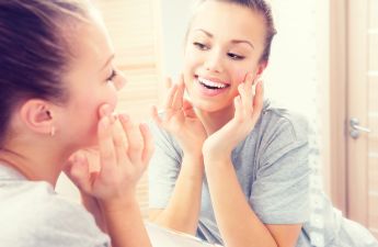 joyful young woman looks in the mirror
