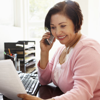 Senior Hispanic woman receptionist at Elegant Smiles