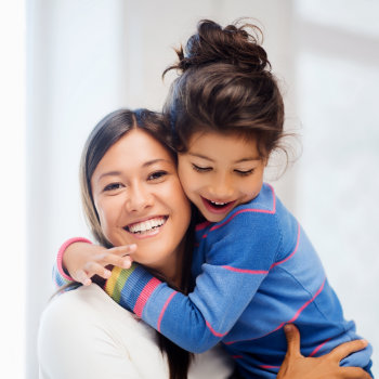 Happy mother hugging daughter Elegant Smiles care