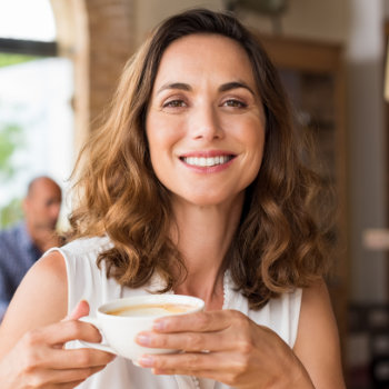 Mature woman smiling holding cup Elegant Smiles care