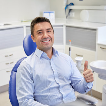 Satisfied man thumbs up in chair Elegant Smiles visit
